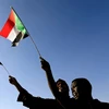 Người dân Sudan cầm quốc kỳ trong một cuộc tuần hành. (Nguồn: Reuters)
