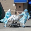 Nhân viên y tế chuyển thi thể bệnh nhân mắc COVID-19 ra nhà xác dã chiến bên ngoài một bệnh viện ở New York, Mỹ ngày 6/4/2020. (Nguồn: AFP/TTXVN)