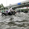 Nước ngập nhiều nơi đến hơn nửa mét khiến người dân di chuyển hết sức khó khăn. (Ảnh: Hồng Giang/TTXVN)