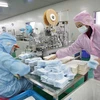 Công nhân may khẩu trang y tế tại một nhà máy ở Vũ Hán, Trung Quốc. (Nguồn: THX/TTXVN)