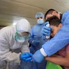 Nhân viên y tế lấy mẫu xét nghiệm COVID-19 cho một em nhỏ tại Baghdad, Iraq. (Nguồn: THX/TTXVN)