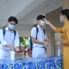 Học sinh trường THPT Phan Châu Trinh đo thân nhiệt, sát khuẩn trước khi vào lớp. (Ảnh: Văn Dũng/TTXVN)