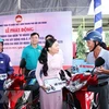 Bà Phan Kiều Thanh Hương, Phó Chủ tịch Ủy ban Mặt trận Tổ quốc Việt Nam Thành phố Hồ Chí Minh (giữa) trao tặng tượng trưng phương tiện sinh kế cho người nghèo. (Ảnh: Xuân Khu/TTXVN) 