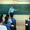 Thầy Vũ Văn Hợp hướng dẫn học sinh ôn luyện môn Hóa học. (Ảnh: Nguyễn Lành/TTXVN)