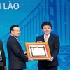 Phó Thủ tướng chính phủ Lào Somdee Duangdee (giữa) trao tặng Huân chương Lao động hạng Nhất cho LaoVietBank. (Ảnh: Xuân Tú/TTXVN)