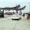 Lực lượng chức năng làm nhiệm vụ hướng dẫn, phân luồng giao thông, khai báo y tế tại chốt trạm cầu Bạch Đằng, thị xã Quảng Yên. (Ảnh: TTXVN)
