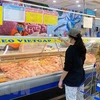 Người tiêu dùng Thành phố Hồ Chí Minh mua thịt lợn tại Co.opmart Vạn Hạnh, quận 10. (Ảnh: TTXVN phát)