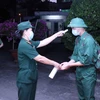 Các thanh niên lên đường nhập ngũ được kiểm tra thân nhiệt, rửa tay sát khuẩn tại điểm giao nhận quân tổ chức tại Quận 5, Thành phố Hồ Chí Minh. (Ảnh: Xuân Khu/TTXVN)