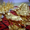 Gia đình nghệ nhân Nguyễn Anh Chung thếp vàng lên tượng trâu vàng cho khách hàng. (Ảnh: Danh Lam/TTXVN)