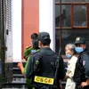 Dẫn giải bị cáo Trịnh Thị Hồng Hoa (áo trắng) sau khi phiên tòa hoãn. (Ảnh: Thành Chung/TTXVN)