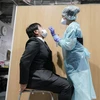 Nhân viên y tế lấy mẫu xét nghiệm COVID-19 tại sân bay Narita, Nhật Bản. (Ảnh: AFP/TTXVN)