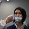 Nhân viên y tế lấy mẫu xét nghiệm COVID-19 tại Tokyo, Nhật Bản. (Nguồn: AFP/TTXVN)