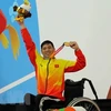 Vận động viên Võ Thanh Tùng tự hào giơ cao tấm huy chương vàng thứ 3 tại Asian Para Games 2018. (Ảnh: Hải Ngọc/TTXVN)
