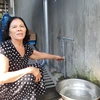 Bà Nguyễn Thị Nữ ở xã Bình Tường bị ngộ độc nên ngưng không sử dụng nước máy trong nhiều ngày nay mà chuyển sang dùng nước bình. (Ảnh: Tường Quân/TTXVN)