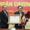 Phó Thủ tướng Thường trực Trương Hòa Bình trao tặng Huân chương Độc lập hạng Nhì cho Nguyên Bộ trưởng Bộ Nội vụ Lê Vĩnh Tân. (Ảnh: Văn Điệp/TTXVN)