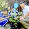 Thầy giáo hướng dẫn cùng Thái và Ngân nghiên cứu cây hoa hồng. (Nguồn: Báo Khánh Hòa)