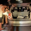 Các chiến sỹ của Đội tuần tra kiểm soát cao tốc số 1 giúp đỡ một lái xe đi mua xăng do xe đang lưu thông trên cao tốc Nội Bài-Lào Cai bị hết xăng. (Ảnh: TTXVN phát)