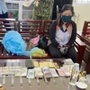 Đối tượng Huỳnh Thị Nguyên cùng tang vật bị bắt giữ phục vụ công tác điều tra. (Ảnh: TTXVN)