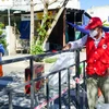 Nhân viên Hội Chữ thập Đỏ thành phố Đà Nẵng đặt túi hàng gia đình ở điểm quy định để người dân trong khu phong tỏa đến nhận, đảm bảo công tác phòng, chống dịch. (Ảnh: TTXVN phát)