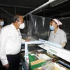 Phó Thủ tướng thường trực Chính phủ Trương Hòa Bình thăm hỏi công nhân tham gia phòng, chống dịch bệnh tại Công ty trách nhiệm hữu hạn Kim may Organ, nơi có khoảng 1.250 lao động, chuyên sản xuất các loại kim may. (Ảnh: Thanh Vũ/TTXVN) 