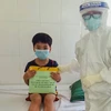 Nhân viên y tế Bệnh viện phổi Đà Nẵng trong trang phục bảo hộ y tế đến tặng quà cho các em thiếu nhi mắc COVID-19 đang điều trị tại bệnh viện. (Ảnh: TTXVN phát)