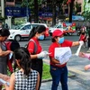 Nhân viên Sở Du lịch Thành phố Hồ Chí Minh phát khẩu trang miễn phí cho khách du lịch. (Ảnh: Đinh Hằng/TTXVN) 