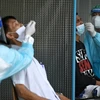 Nhân viên y tế lấy mẫu xét nghiệm COVID-19 tại Bangkok, Thái Lan. (Nguồn: AFP/TTXVN)