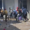 Các đối tượng cướp phá tại một cửa hàng ở Johannesburg, Nam Phi ngày 12/7/2021. (Ảnh: AFP/TTXVN) 