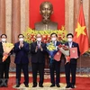 Chủ tịch nước Nguyễn Xuân Phúc trao Quyết định, Thủ tướng Phạm Minh Chính tặng hoa cho các Phó Thủ tướng Chính phủ. (Ảnh: Thống Nhất/TTXVN) 