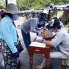 Người dân được kiểm tra thông tin, khai báo y tế trước khi vào chợ Thanh Sơn (phường Thanh Sơn, thành phố Phan Rang-Tháp Chàm) để phòng, chống dịch COVID-19. (Ảnh: Nguyễn Thành/TTXVN)