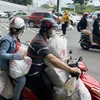 Xe máy người dân chất đầy thực phẩm sau khi mua từ Trung tâm thương mại Aeon Mall Tân Phú. (Ảnh: Mạnh Linh/TTXVN) 