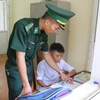 Chiến sỹ Đồn Biên phòng Pa Thơm (Bộ đội Biên phòng tỉnh Điện Biên) trực tiếp tiếp kèm cặp, hỗ trợ các cháu con nuôi của đơn vị học tập hằng ngày trong góc học tập riêng của các cháu. (Ảnh: Xuân Tiến/TTXVN)