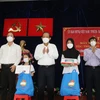 Ông Trương Hòa Bình cùng đại diện lãnh đạo TP Hồ Chí Minh và đơn vị tài trợ trao máy tính bảng và quà cho đại diện các em học sinh dân tộc thiểu số khó khăn trên địa bàn. (Ảnh: Xuân Khu/TTXVN)