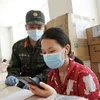 Cán bộ, chiến sỹ hỗ trợ các em học trực tuyến tại lớp học dã chiến ở chung cư 1050 (quận Bình Thạnh). (Ảnh: Thu Hương/TTXVN)