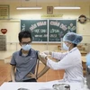 Nhân viên y tế tiêm vaccine phòng COVID-19 cho người dân phường Hạ Đình, quận Thanh Xuân. (Ảnh: Minh Quyết/TTXVN) 