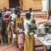Cha mẹ và các bệnh nhi xếp hàng nhận thức ăn tại bệnh viện Berberati, Cộng hòa Trung Phi. (Ảnh: AFP/TTXVN)