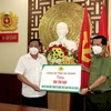 Đại tá Đinh Văn Nơi, Giám đốc Công an tỉnh An Giang (phải) trao biểu trưng tặng 200 tấn gạo cho các bếp ăn tại các khu cách ly tập trung phục vụ người dân từ các tỉnh về quê tự phát. (Ảnh: TTXVN phát)