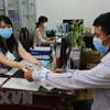 Người lao động nhận tiền hỗ trợ tại Bảo hiểm xã hội tỉnh Bạc Liêu. (Ảnh: Tuấn Kiệt/TTXVN) 