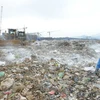 Công ty TNHH MTV Môi trường Đô thị Hà Nội rắc chế phẩm khử mùi tại bãi rác Nam Sơn. (Ảnh: Mạnh Khánh/TTXVN)
