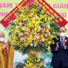 Chủ tịch nước Nguyễn Xuân Phúc tặng hoa chúc mừng Giáo hội Phật giáo Việt Nam. (Ảnh: Thống Nhất/TTXVN) 