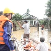 Tại huyện Tuy Phước, lực lượng chức năng phải dùng canô để hỗ trợ hơn 300 suất nhu yếu phẩm đến người dân xã Phước Nghĩa bị cô lập nhiều ngày qua. (Ảnh: Tường Quân/TTXVN) 