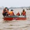 Lực lượng cứu hộ tỉnh Phú Yên dùng xuồng đưa người dân ra khỏi khu vực ngập lụt. (Ảnh: Phạm Cường/TTXVN) 