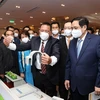 Thủ tướng Phạm Minh Chính và các đại biểu tham quan trưng bày các sản phẩm ứng dụng công nghệ sáng tạo. (Ảnh: Dương Giang/TTXVN) 