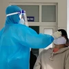 Nhân viên Trạm Y tế xã Phước Nam, huyện Thuận Nam, tỉnh Ninh Thuận lấy mẫu xét nghiệm COVID-19 cho người dân. (Ảnh: Công Thử/TTXVN) 