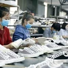Sản xuất giày xuất khẩu sang thị trường châu Âu tại Công ty TNHH Hóa dệt Hà Tây. (Ảnh: Trần Việt/TTXVN) 