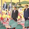 Thủ tướng Phạm Minh Chính và Thủ tướng Lào Phankham Viphavanh trên bục danh dự, nghe quân nhạc cử Quốc thiều hai nước. (Ảnh: Lâm Khánh/TTXVN) 