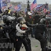 Người biểu tình xung đột với cảnh sát chống bạo động tại Đồi Capitol ở Washington DC., ngày 6/1/2021. (Ảnh: AFP/TTXVN) 