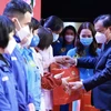 Ủy viên Bộ Chính trị, Bí thư Thành ủy Hà Nội Đinh Tiến Dũng trao quà cho các công nhân, lao động. (Ảnh: TTXVN phát)