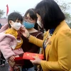 Bà Nguyễn Thị Tuyến, Phó Bí thư Thường trực Thành ủy Hà Nội trao quà cho con công nhân lao động. (Ảnh: TTXVN phát) 