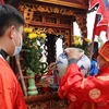 Chủ tế - ông Nguyễn Trọng Thủy, đặt âu gốm đựng nước thiêng lên kiệu để các trai làng rước về đình. (Ảnh: Trung Kiên/TTXVN) 